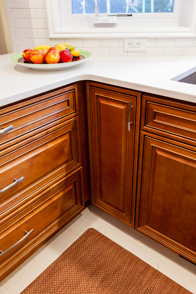 Example of a classic kitchen design in New York with raised-panel cabinets and light wood cabinets