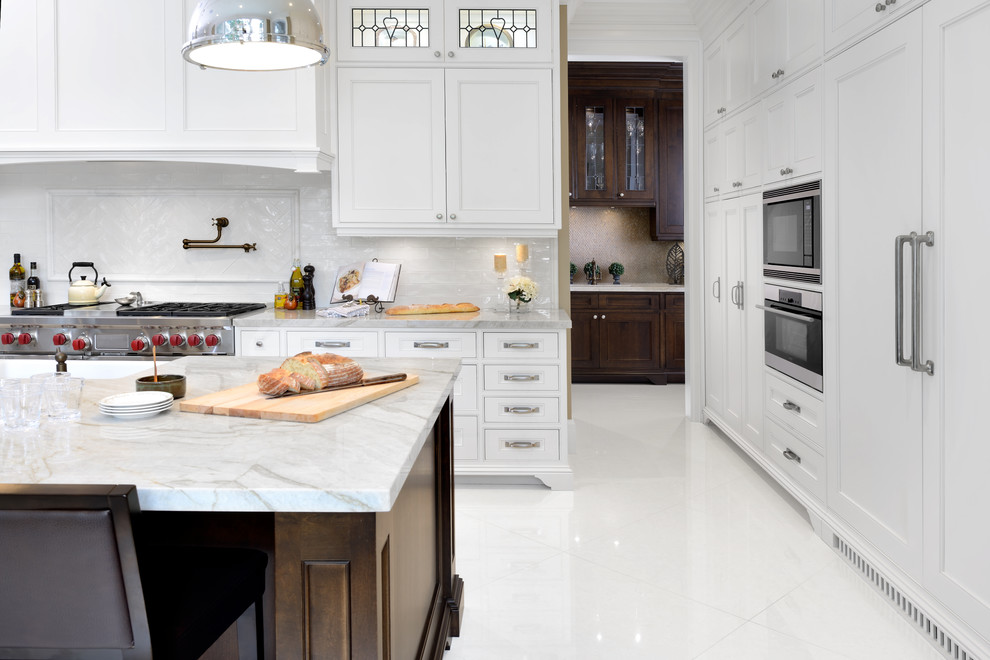 Design ideas for an expansive traditional l-shaped kitchen in Toronto with a belfast sink, shaker cabinets, white cabinets, engineered stone countertops, white splashback, stainless steel appliances, porcelain flooring and an island.