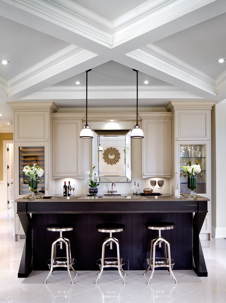 Classic kitchen in Toronto with raised-panel cabinets, beige cabinets and an island.