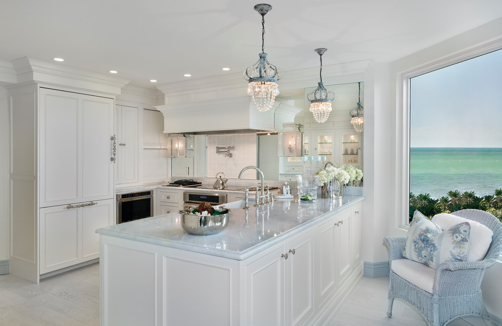 Idéer för ett u-kök, med en rustik diskho, vita skåp, marmorbänkskiva, spegel som stänkskydd, rostfria vitvaror och en halv köksö
