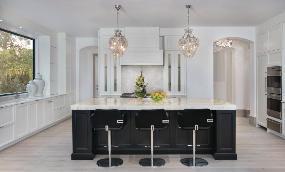 Eat-in kitchen - l-shaped light wood floor eat-in kitchen idea in Miami with an undermount sink, recessed-panel cabinets, white cabinets, onyx countertops, stone slab backsplash, stainless steel appliances and an island