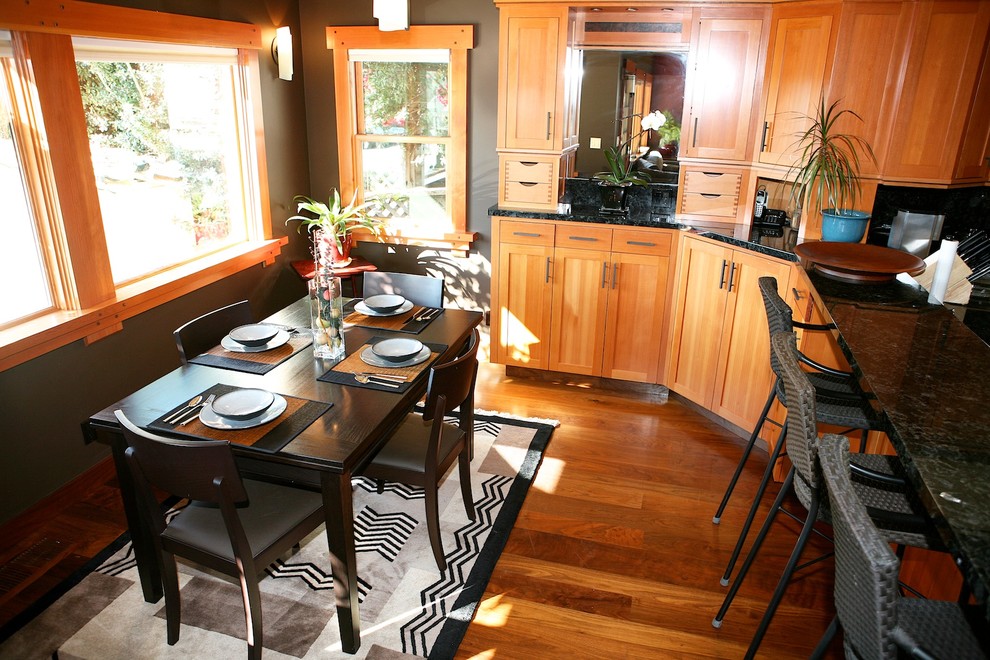 Eat-in kitchen - mid-sized transitional u-shaped dark wood floor eat-in kitchen idea in Other with an undermount sink, recessed-panel cabinets, medium tone wood cabinets, granite countertops, black backsplash, stone slab backsplash, paneled appliances and a peninsula
