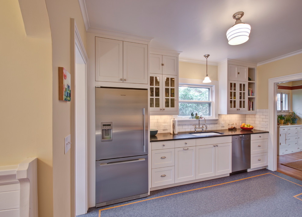 Arts and crafts linoleum floor enclosed kitchen photo in Portland with an undermount sink, recessed-panel cabinets, white cabinets, soapstone countertops, white backsplash, subway tile backsplash and stainless steel appliances