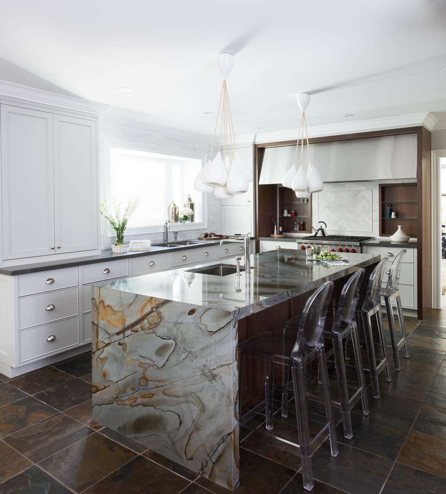 Klassisk inredning av ett mellanstort flerfärgad flerfärgat l-kök, med en undermonterad diskho, vita skåp, marmorbänkskiva, vitt stänkskydd, rostfria vitvaror, skiffergolv, en köksö, brunt golv och stänkskydd i marmor