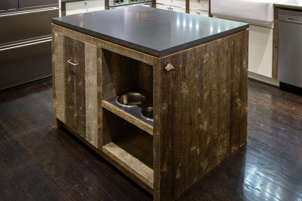 Inspiration for a mid-sized industrial u-shaped dark wood floor kitchen remodel in New York with a farmhouse sink, flat-panel cabinets, white cabinets, quartzite countertops, stainless steel appliances and an island