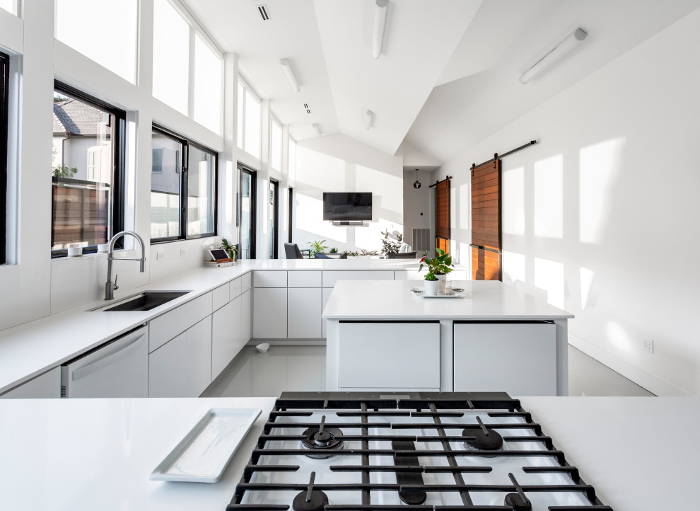 Idéer för funkis vitt u-kök, med en undermonterad diskho, släta luckor, vita skåp, en köksö och grått golv