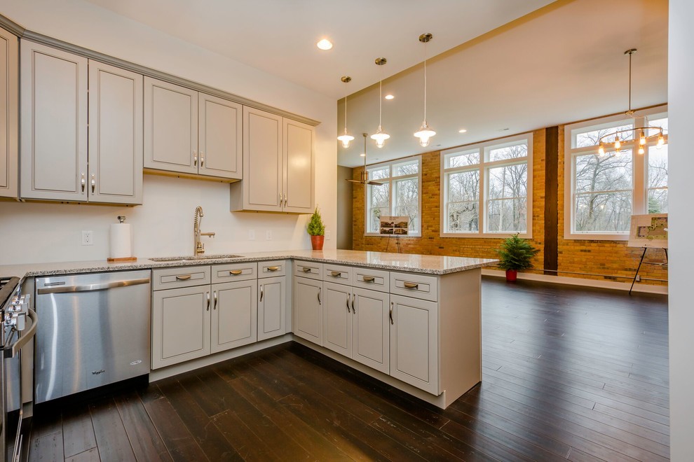 Example of a mid-sized transitional u-shaped dark wood floor and brown floor eat-in kitchen design in Other with an undermount sink, recessed-panel cabinets, gray cabinets, granite countertops, white backsplash, stainless steel appliances, a peninsula and multicolored countertops
