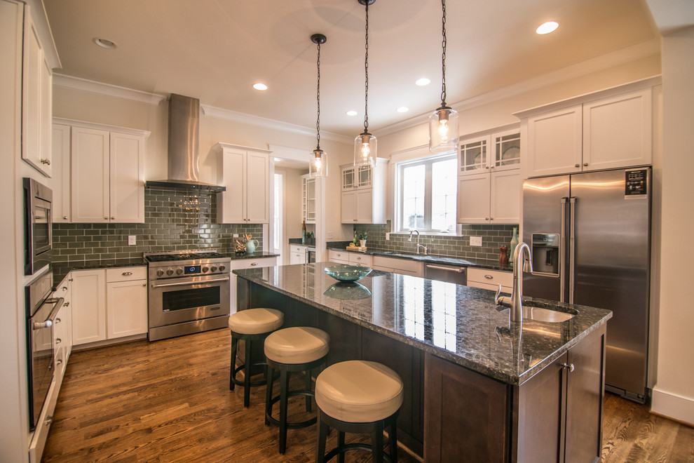 Arts and crafts u-shaped dark wood floor eat-in kitchen photo in DC Metro with an undermount sink, shaker cabinets, white cabinets, granite countertops, green backsplash, glass tile backsplash, stainless steel appliances and an island