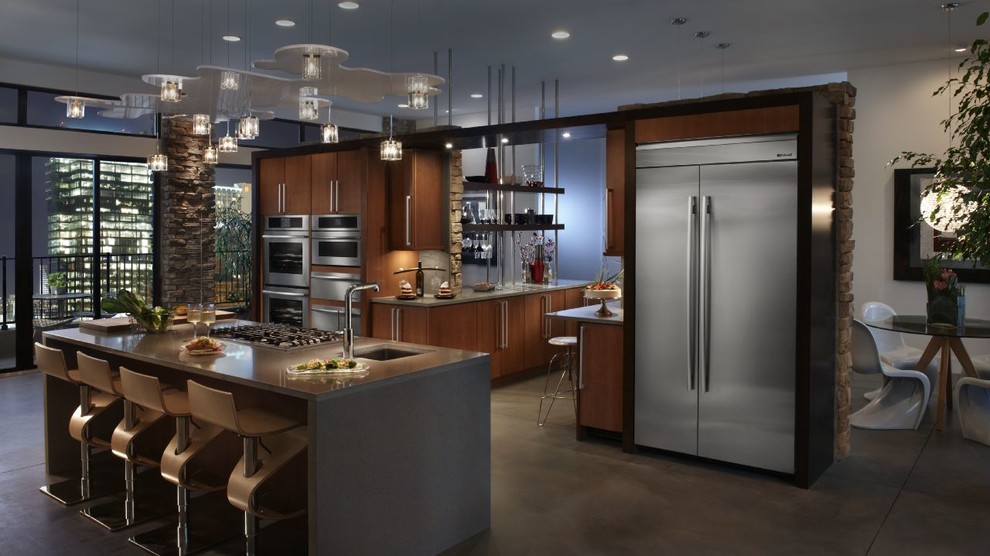 Imagen de cocina comedor actual grande con puertas de armario de madera oscura, electrodomésticos de acero inoxidable y una isla