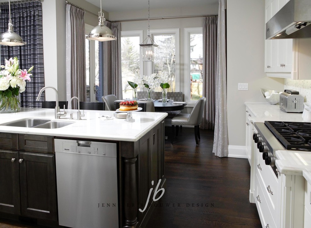 Example of a mid-sized trendy dark wood floor eat-in kitchen design in Toronto with a double-bowl sink, shaker cabinets, white cabinets, quartzite countertops, white backsplash, stone tile backsplash, stainless steel appliances and an island
