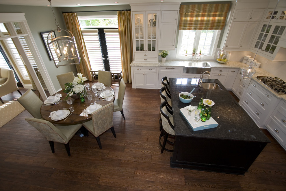 Eat-in kitchen - mid-sized contemporary u-shaped medium tone wood floor eat-in kitchen idea in Toronto with a farmhouse sink, shaker cabinets, white cabinets, marble countertops, white backsplash, ceramic backsplash, stainless steel appliances and an island