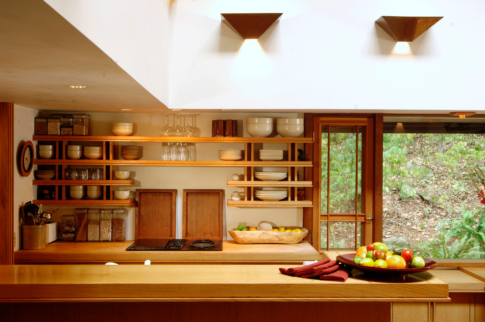 Große Moderne Küche in U-Form mit flächenbündigen Schrankfronten, hellen Holzschränken, Arbeitsplatte aus Holz, Schieferboden und braunem Boden in Sonstige
