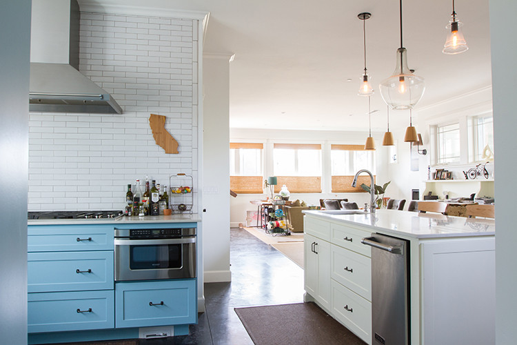 Bild på ett funkis kök, med en enkel diskho, skåp i shakerstil, blå skåp, bänkskiva i kvarts, vitt stänkskydd, stänkskydd i tunnelbanekakel, rostfria vitvaror och betonggolv