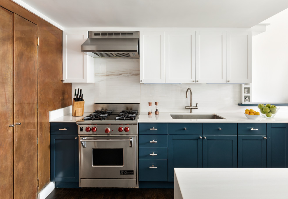 Foto på ett mellanstort eklektiskt vit kök, med en undermonterad diskho, skåp i shakerstil, blå skåp, marmorbänkskiva, vitt stänkskydd, stänkskydd i marmor, rostfria vitvaror, mellanmörkt trägolv, en halv köksö och brunt golv