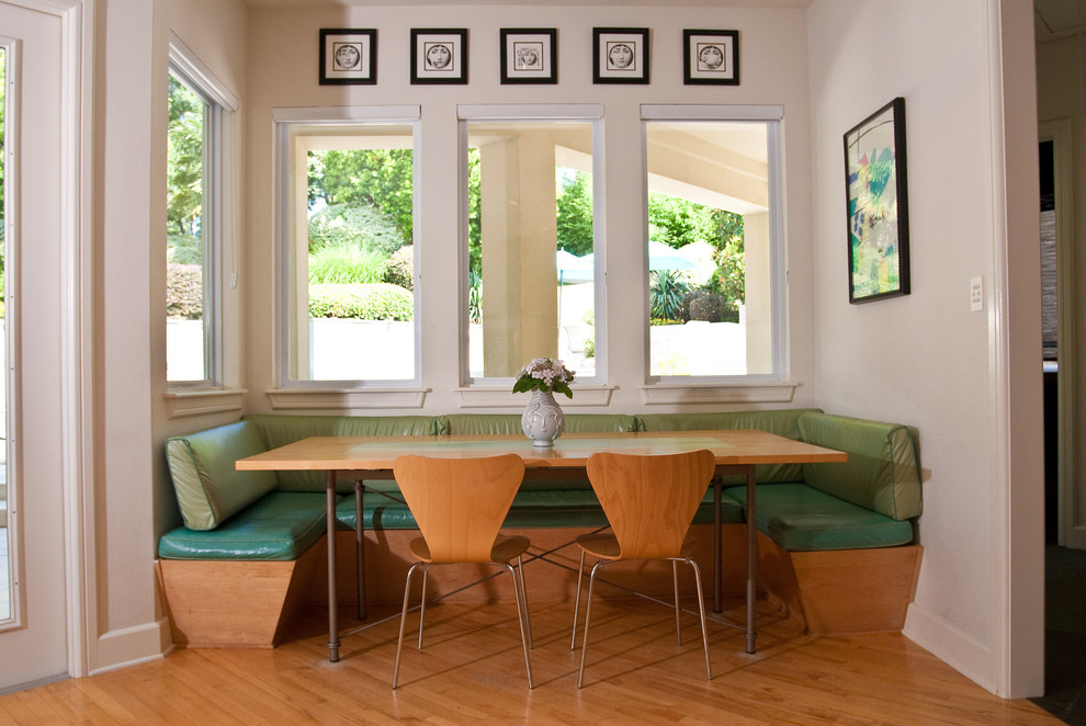 Foto di una sala da pranzo aperta verso la cucina minimalista con parquet chiaro