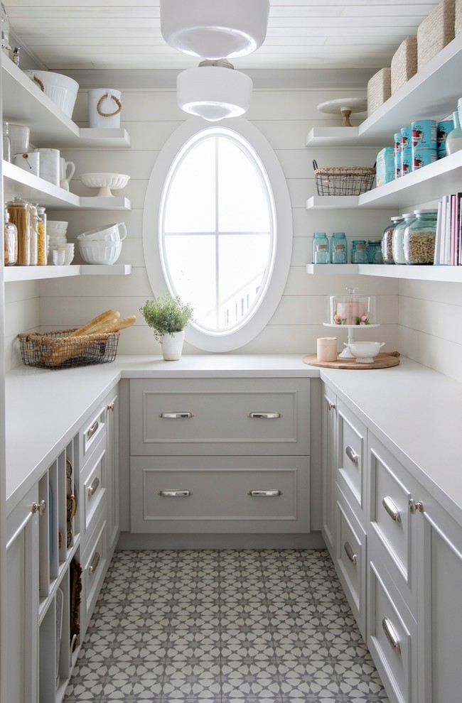 Cette image montre une cuisine rustique en U avec un placard avec porte à panneau encastré, des portes de placard grises, un sol multicolore et un plan de travail blanc.