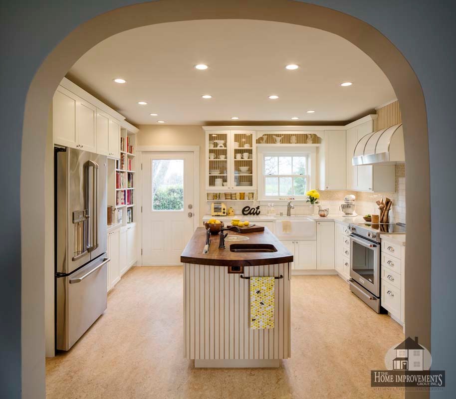 Photo of a medium sized rural u-shaped kitchen/diner in Sacramento with a belfast sink, shaker cabinets, white cabinets, engineered stone countertops, yellow splashback, ceramic splashback, lino flooring and an island.