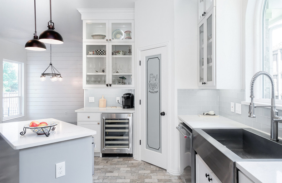 Idéer för ett mellanstort lantligt vit kök, med en rustik diskho, skåp i shakerstil, vita skåp, bänkskiva i kvarts, blått stänkskydd, stänkskydd i glaskakel, rostfria vitvaror, klinkergolv i porslin, en köksö och grått golv