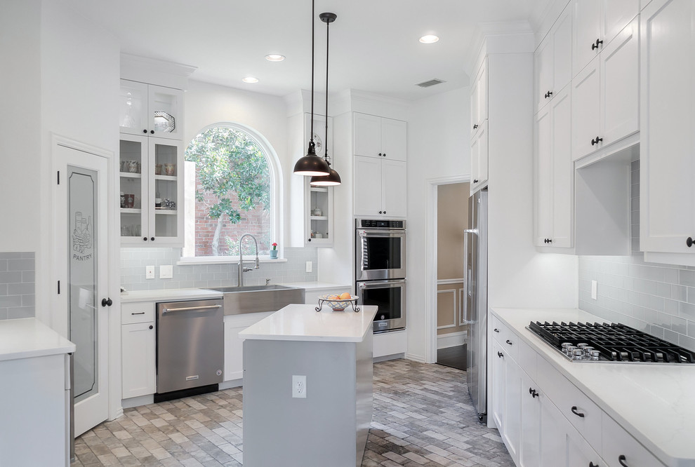 Exempel på ett mellanstort lantligt vit vitt kök, med en rustik diskho, skåp i shakerstil, vita skåp, bänkskiva i kvarts, blått stänkskydd, stänkskydd i glaskakel, rostfria vitvaror, klinkergolv i porslin, en köksö och grått golv