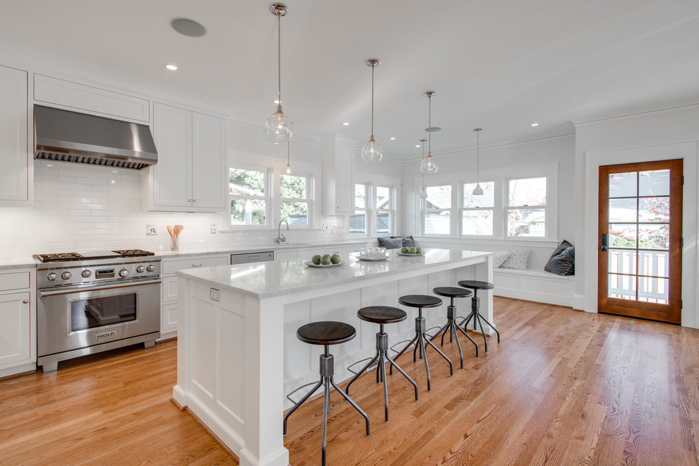Urige Küche mit Schrankfronten im Shaker-Stil, weißen Schränken, Küchenrückwand in Weiß, Rückwand aus Metrofliesen und Küchengeräten aus Edelstahl in Portland