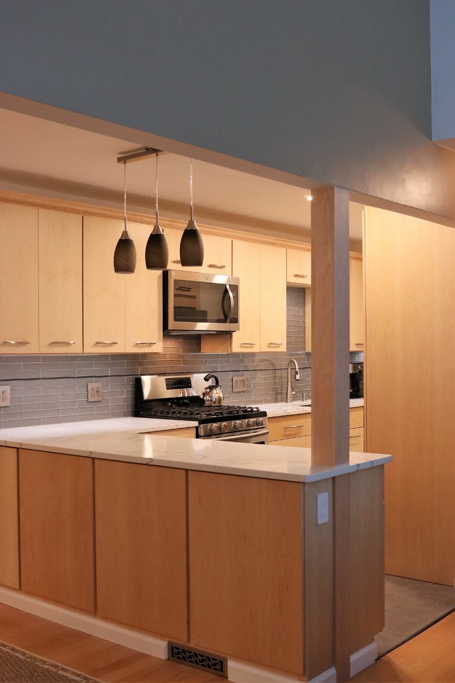 Idéer för ett litet modernt kök, med en undermonterad diskho, släta luckor, skåp i ljust trä, granitbänkskiva, grått stänkskydd, stänkskydd i glaskakel, rostfria vitvaror, skiffergolv, en köksö och grått golv