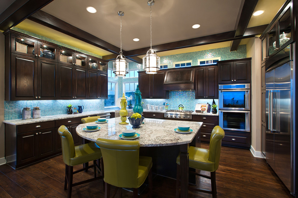 На фото: кухня в классическом стиле с фасадами с выступающей филенкой, темными деревянными фасадами, синим фартуком и техникой из нержавеющей стали