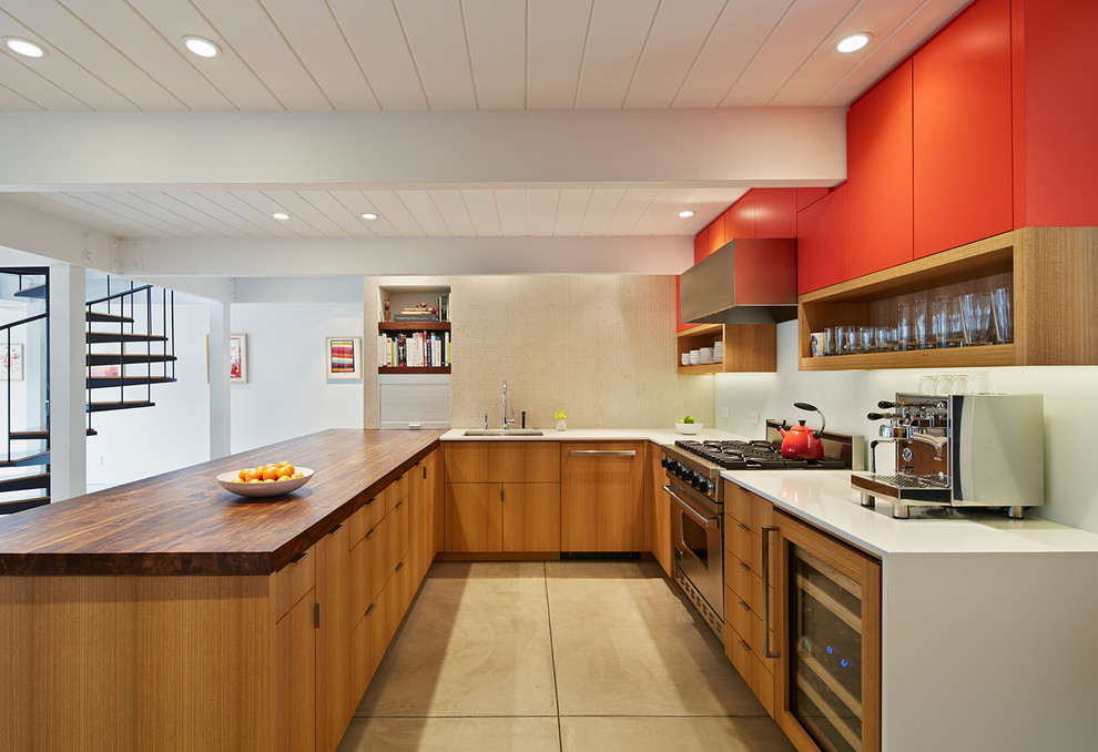 На фото: п-образная кухня в современном стиле с врезной мойкой, плоскими фасадами, красными фасадами, техникой из нержавеющей стали, полуостровом, бежевым полом, разноцветной столешницей и барной стойкой