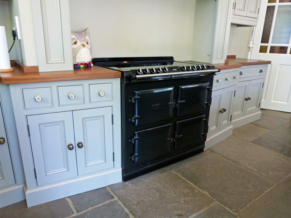 Photo of a country l-shaped open plan kitchen in Other with beaded cabinets and an island.