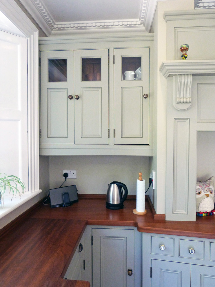 Rural l-shaped open plan kitchen in Other with beaded cabinets and an island.