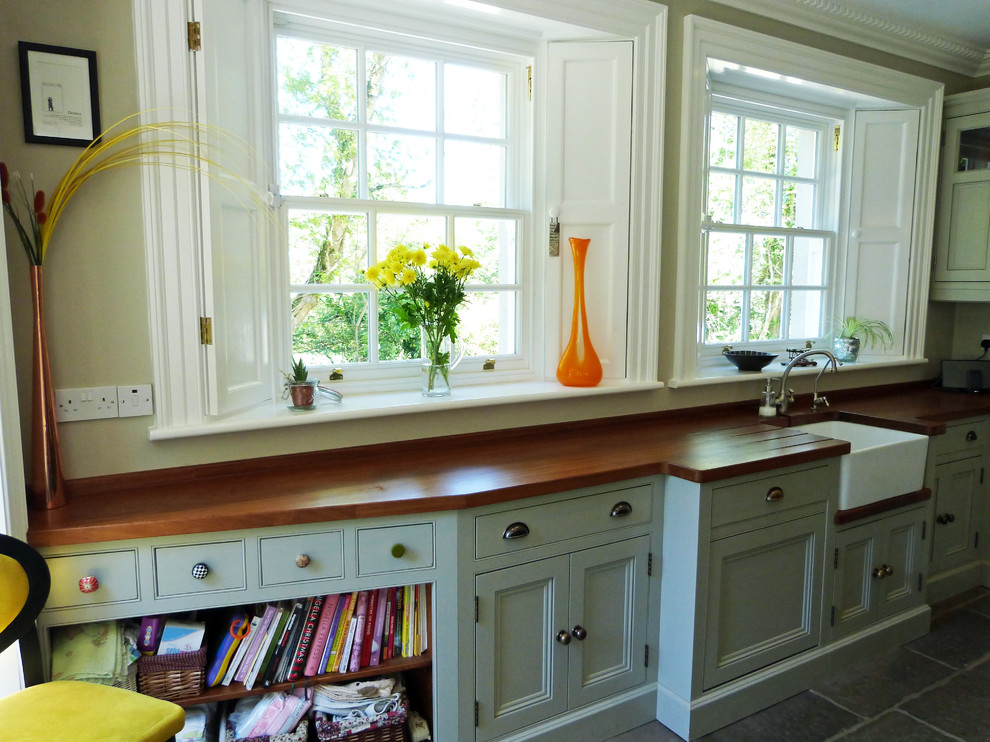 This is an example of a l-shaped open plan kitchen in Other with beaded cabinets and an island.