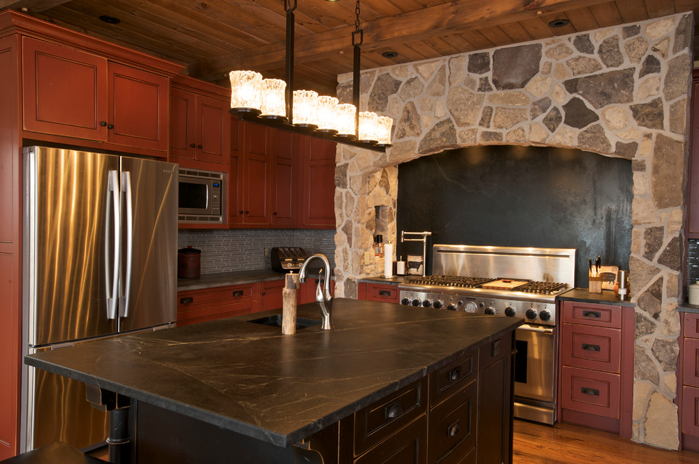 Wohnküche in L-Form mit Unterbauwaschbecken, roten Schränken, Onyx-Arbeitsplatte, Küchenrückwand in Grau, Rückwand aus Glasfliesen, Küchengeräten aus Edelstahl, braunem Holzboden und Kücheninsel in Toronto