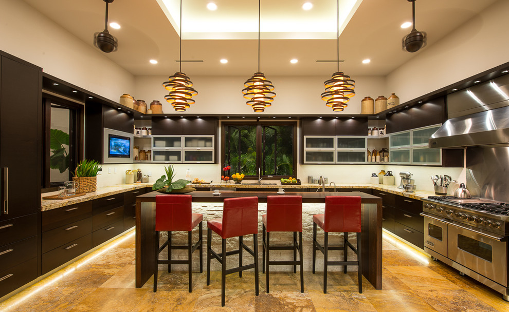 Küche in U-Form mit Glasfronten, Granit-Arbeitsplatte, dunklen Holzschränken und Küchengeräten aus Edelstahl in Sonstige