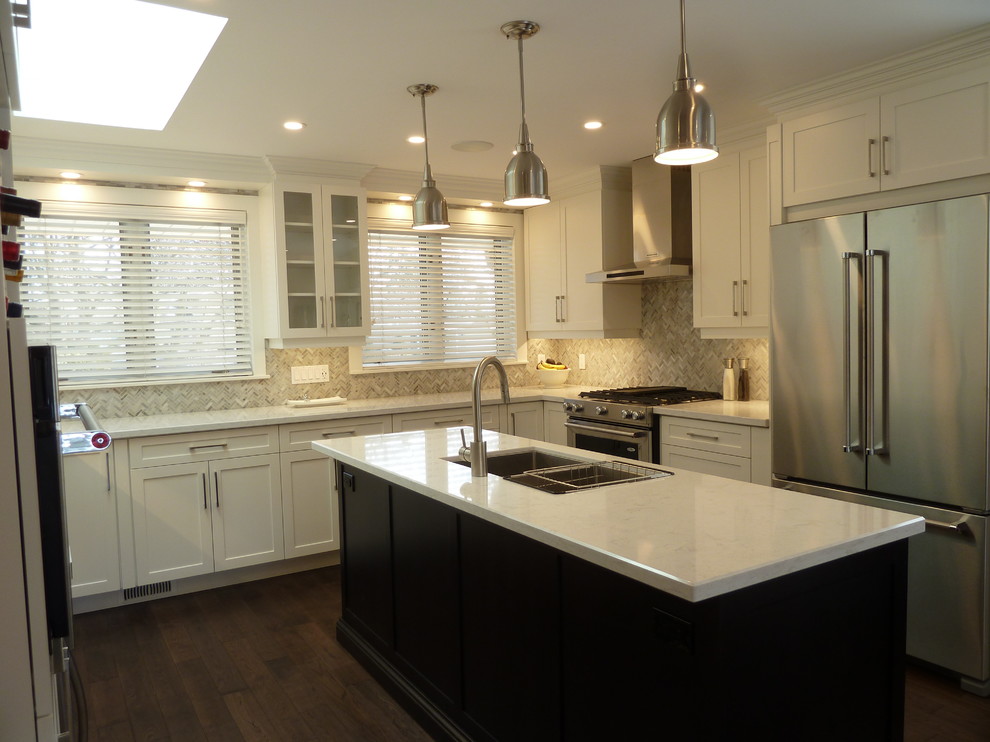 This is an example of a large classic u-shaped open plan kitchen in Toronto with shaker cabinets, white cabinets, stainless steel appliances, a double-bowl sink, multi-coloured splashback, dark hardwood flooring, an island and brown floors.