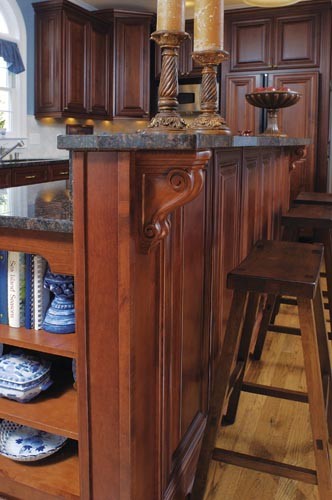 Klassisk inredning av ett stort kök, med en undermonterad diskho, luckor med infälld panel, skåp i mörkt trä, granitbänkskiva, beige stänkskydd, stänkskydd i stenkakel, rostfria vitvaror, mellanmörkt trägolv och en köksö