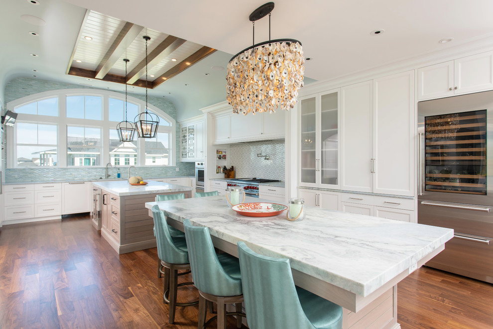 Kitchen - coastal medium tone wood floor kitchen idea in Other with shaker cabinets, white cabinets, blue backsplash, stainless steel appliances, two islands and white countertops