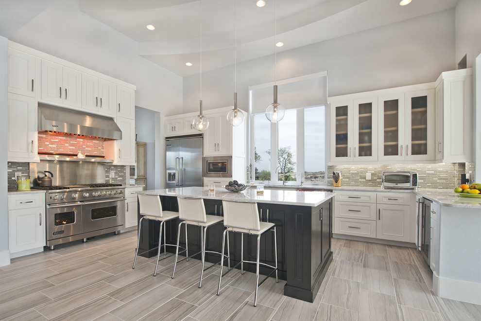 Inspiration for a transitional u-shaped kitchen remodel in Austin with beaded inset cabinets, beige cabinets, multicolored backsplash, mosaic tile backsplash, stainless steel appliances and an island