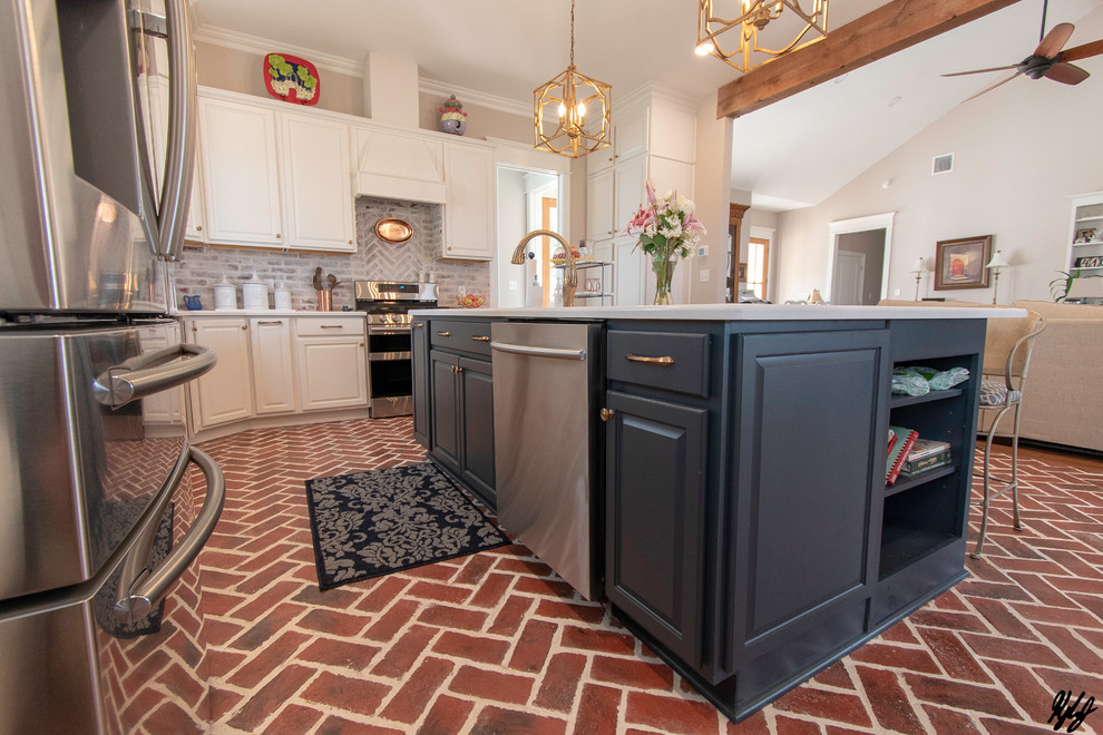 Immagine di una cucina chic con top in granito, elettrodomestici in acciaio inossidabile, pavimento in mattoni e top bianco