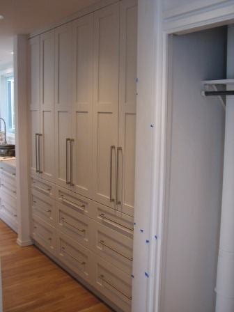 Classic galley open plan kitchen in Seattle with shaker cabinets and white cabinets.
