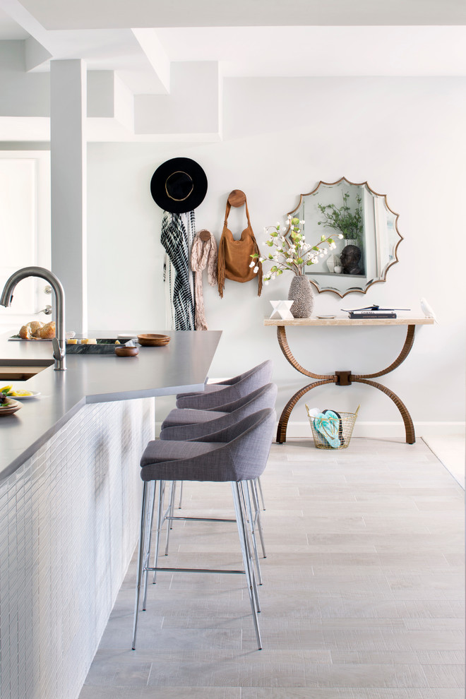 На фото: кухня в современном стиле с обеденным столом, врезной мойкой, белым фартуком, фартуком из плитки мозаики, полом из керамогранита, островом и серым полом с