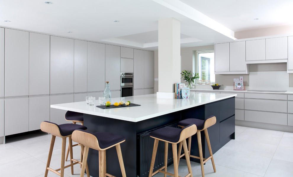 Large contemporary l-shaped kitchen in Dublin with flat-panel cabinets, white cabinets and an island.
