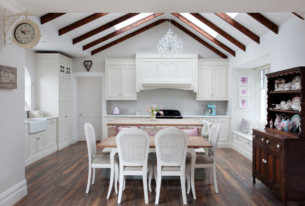 Mittelgroße Shabby-Style Küche in L-Form mit Schrankfronten mit vertiefter Füllung, weißen Schränken, Arbeitsplatte aus Holz, dunklem Holzboden, braunem Boden, Landhausspüle und beiger Arbeitsplatte in Dublin