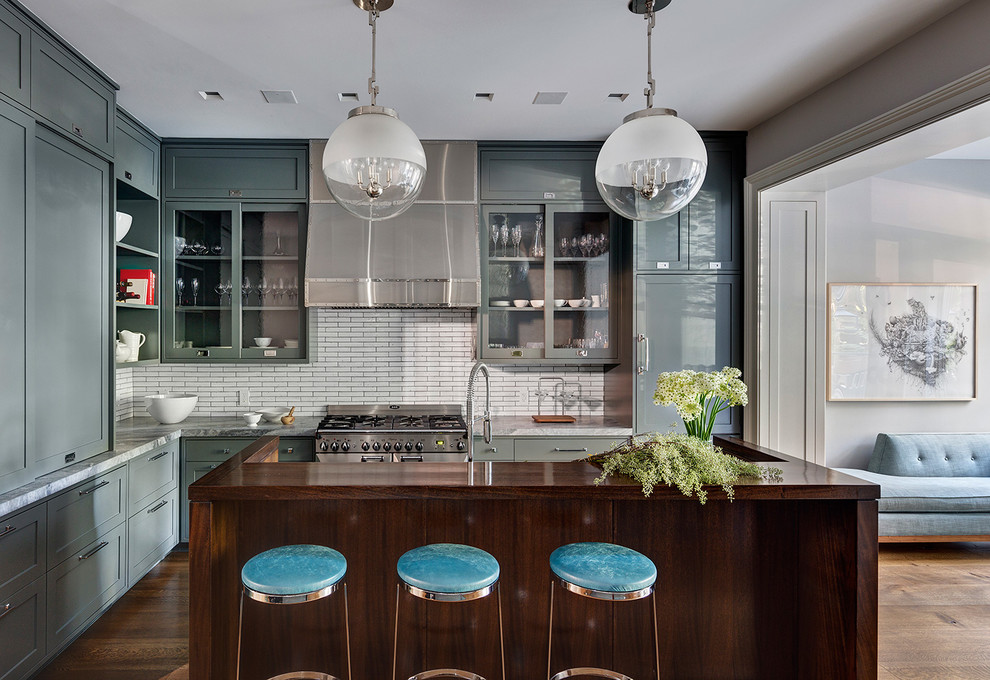 Idee per una cucina classica con ante di vetro, paraspruzzi bianco, pavimento in legno massello medio e elettrodomestici in acciaio inossidabile