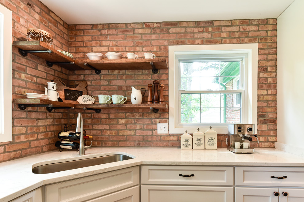 Photo of a medium sized farmhouse u-shaped enclosed kitchen in DC Metro with a submerged sink, white cabinets, stainless steel appliances, shaker cabinets, wood worktops, red splashback, brick splashback, dark hardwood flooring, a breakfast bar and brown floors.