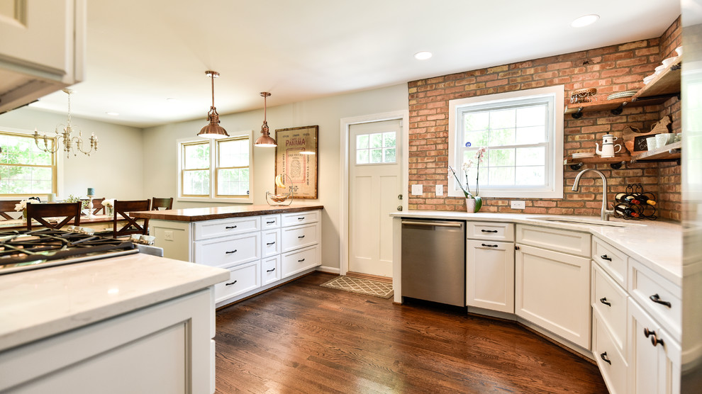 Enclosed kitchen - mid-sized cottage u-shaped dark wood floor and brown floor enclosed kitchen idea in DC Metro with an undermount sink, white cabinets, stainless steel appliances, shaker cabinets, wood countertops, red backsplash, brick backsplash and a peninsula