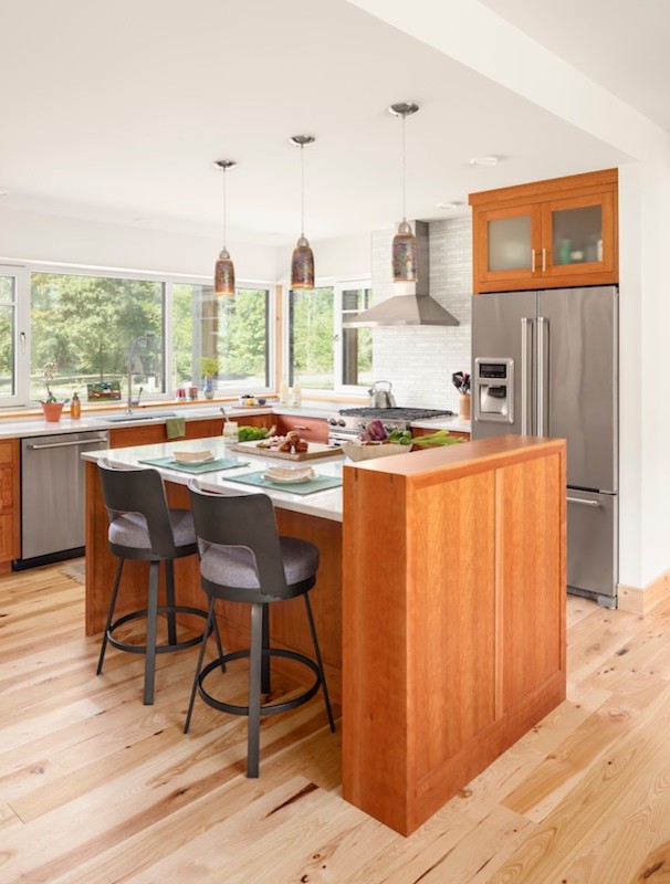 Foto på ett mellanstort funkis kök, med skåp i mellenmörkt trä, ljust trägolv, en köksö och beiget golv