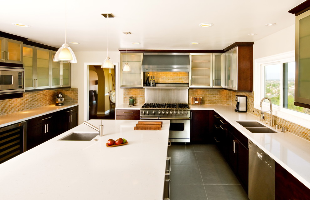 Exempel på ett modernt kök, med stänkskydd i stickkakel, rostfria vitvaror, en dubbel diskho, luckor med glaspanel, skåp i rostfritt stål och gult stänkskydd