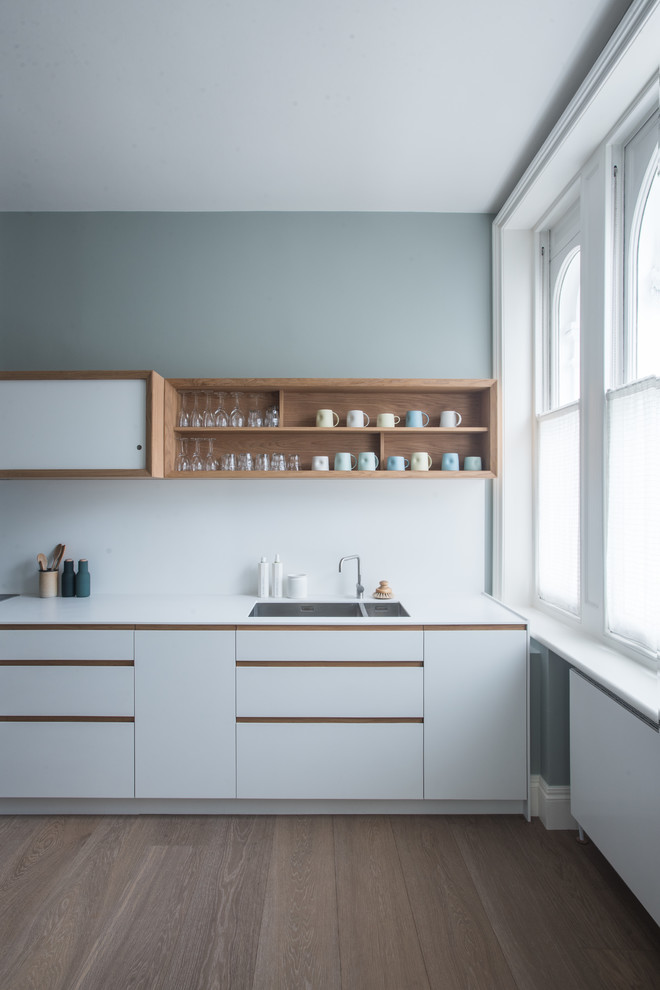 Design ideas for a small contemporary galley enclosed kitchen in London with white cabinets.