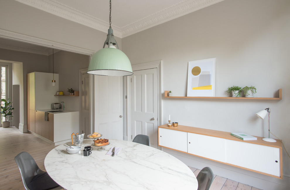 Open concept kitchen - mid-sized contemporary galley light wood floor open concept kitchen idea in London with an integrated sink, solid surface countertops and white backsplash