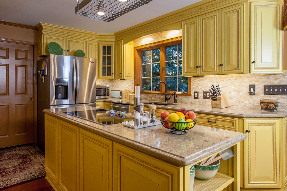 Exempel på ett mellanstort, avskilt lantligt l-kök, med en undermonterad diskho, luckor med profilerade fronter, gula skåp, bänkskiva i kvarts, beige stänkskydd, stänkskydd i stenkakel, rostfria vitvaror, mellanmörkt trägolv, en köksö och brunt golv