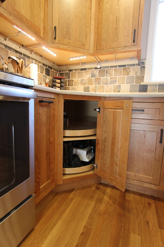 Bild på ett mellanstort vintage kök, med en undermonterad diskho, skåp i shakerstil, skåp i ljust trä, bänkskiva i kvarts, flerfärgad stänkskydd, stänkskydd i stenkakel, rostfria vitvaror, ljust trägolv och en köksö